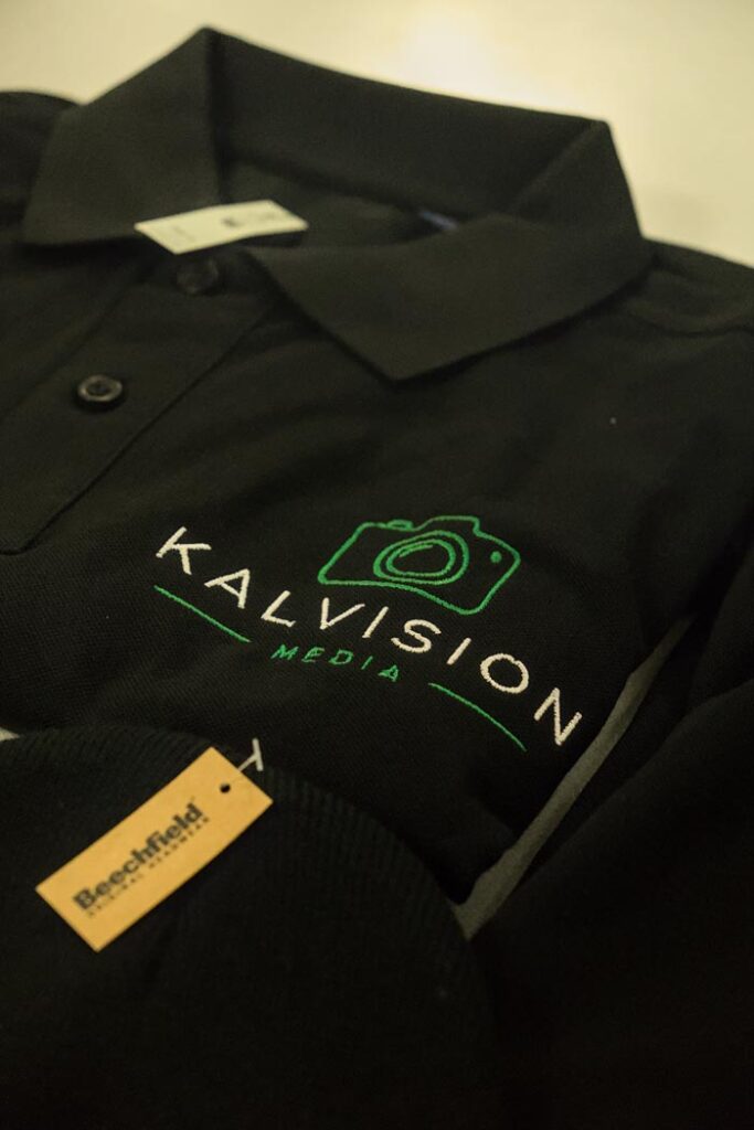 Black KalVision polo shirt with an embroidered company logo